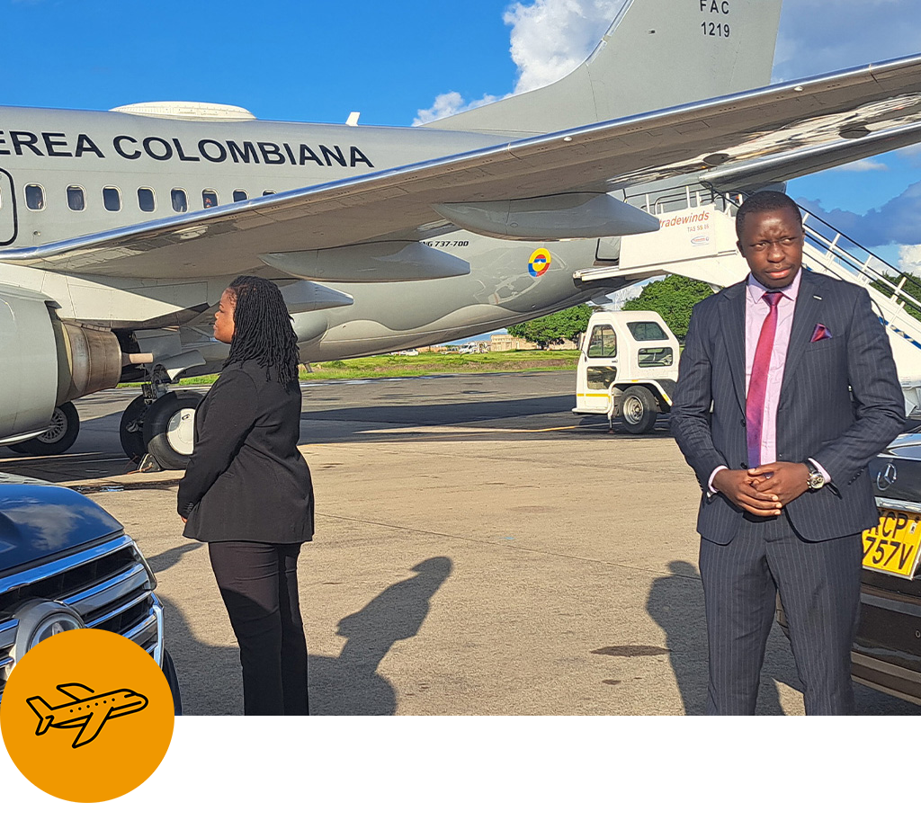 Comfleete airport transfer service showing business travellers and a professional chauffeur beside an aircraft at JKIA airport, illustrating coordinated airport pickups and drop-offs in Nairobi, Kenya.