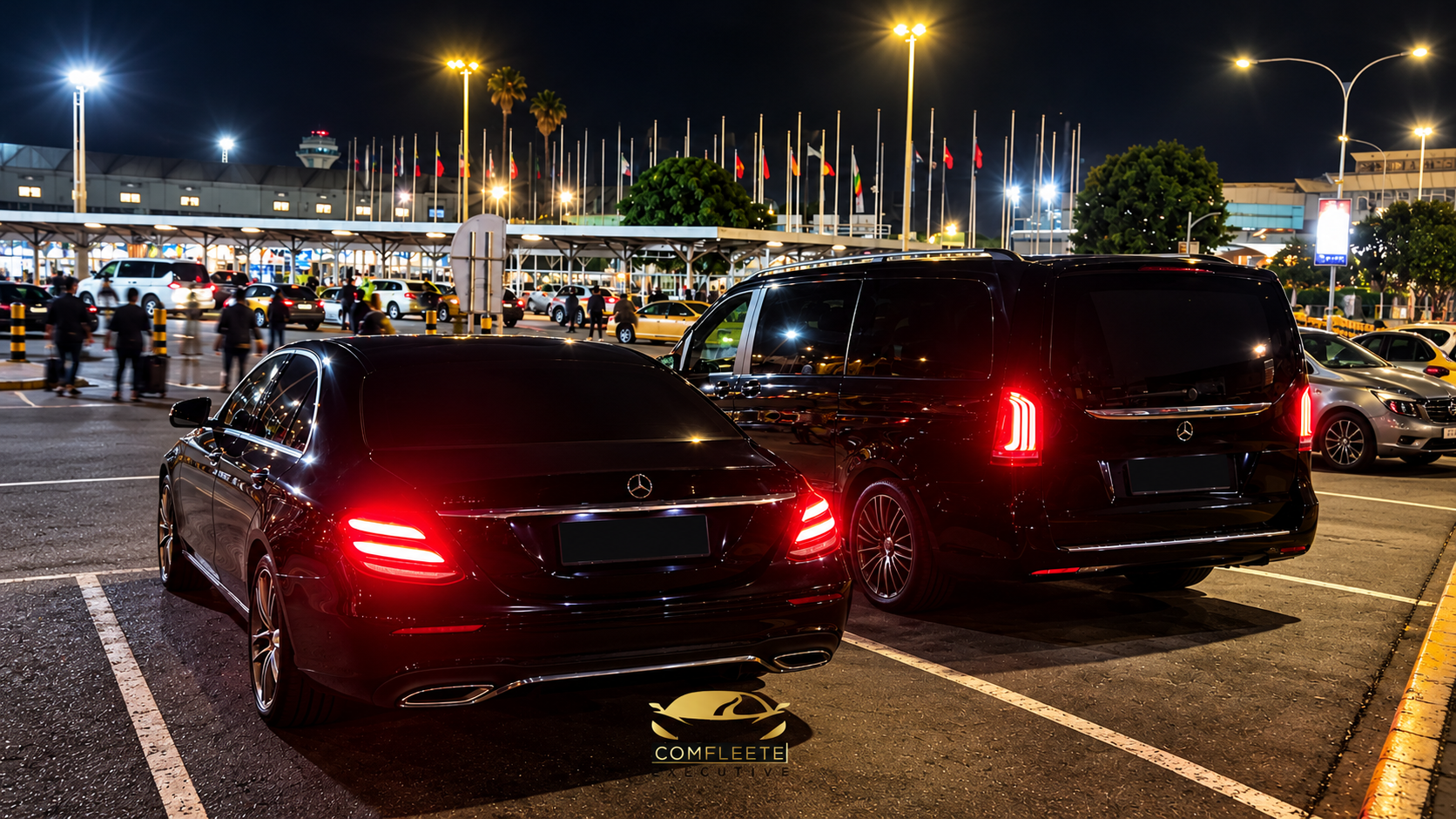 Comfleete airport transfer services featuring luxury black Mercedes-Benz vehicles at a brightly lit airport arrivals area in Nairobi, Kenya.